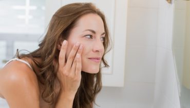 woman puts cream under her eyes