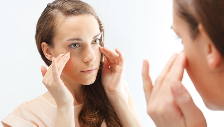 young woman applies eye cream