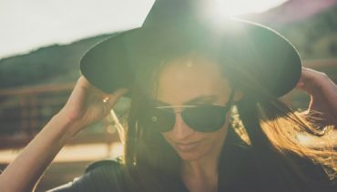 woman with hat and sunglasses under the sun