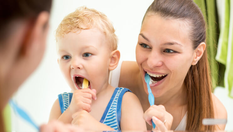 mom with kid brushing their teeth