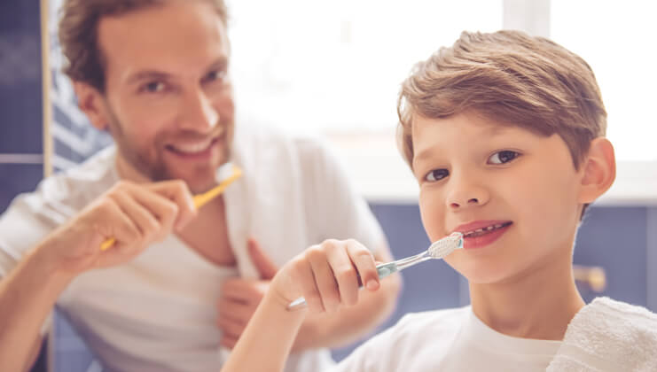 son and father brushing his teeth