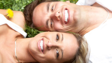 couple on the grass smiles