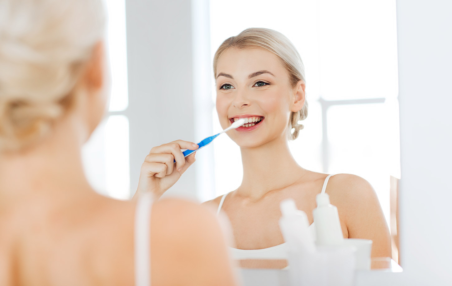 blonde woman brushes her teeth