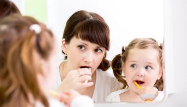 mom and daughter brushing their teeth