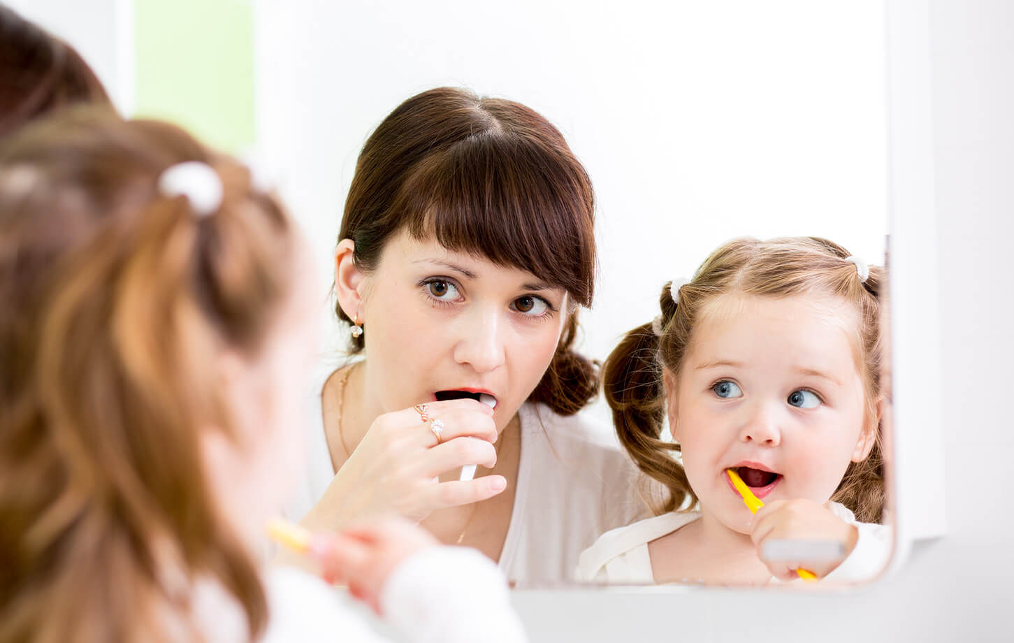 mom and daughter brushing their teeth