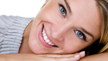 young blonde hair woman with blue eyes smiles