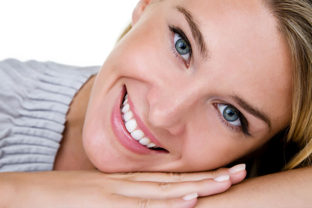 young blonde hair woman with blue eyes smiles