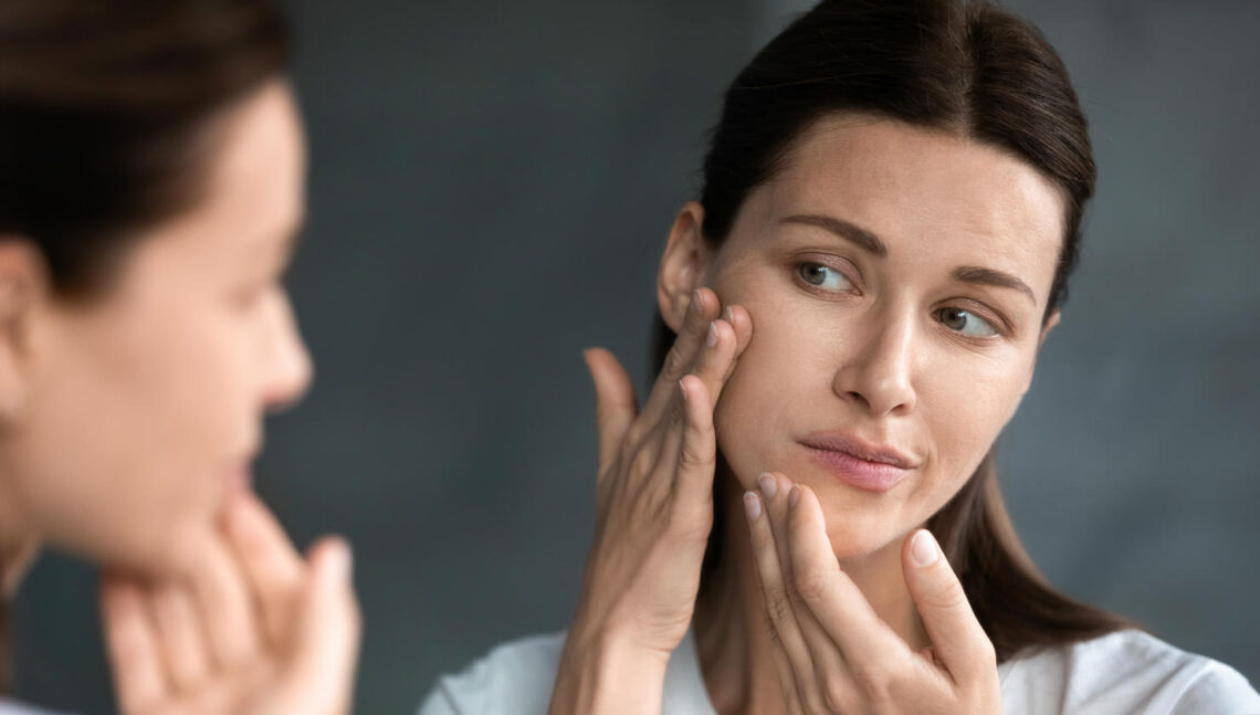 woman checkeing her face on the mirror