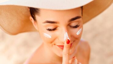 woman applying sunscreen on face