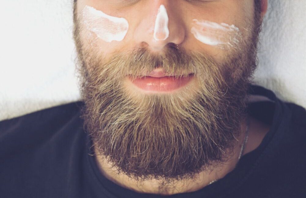 bearded man with cream on cheeks