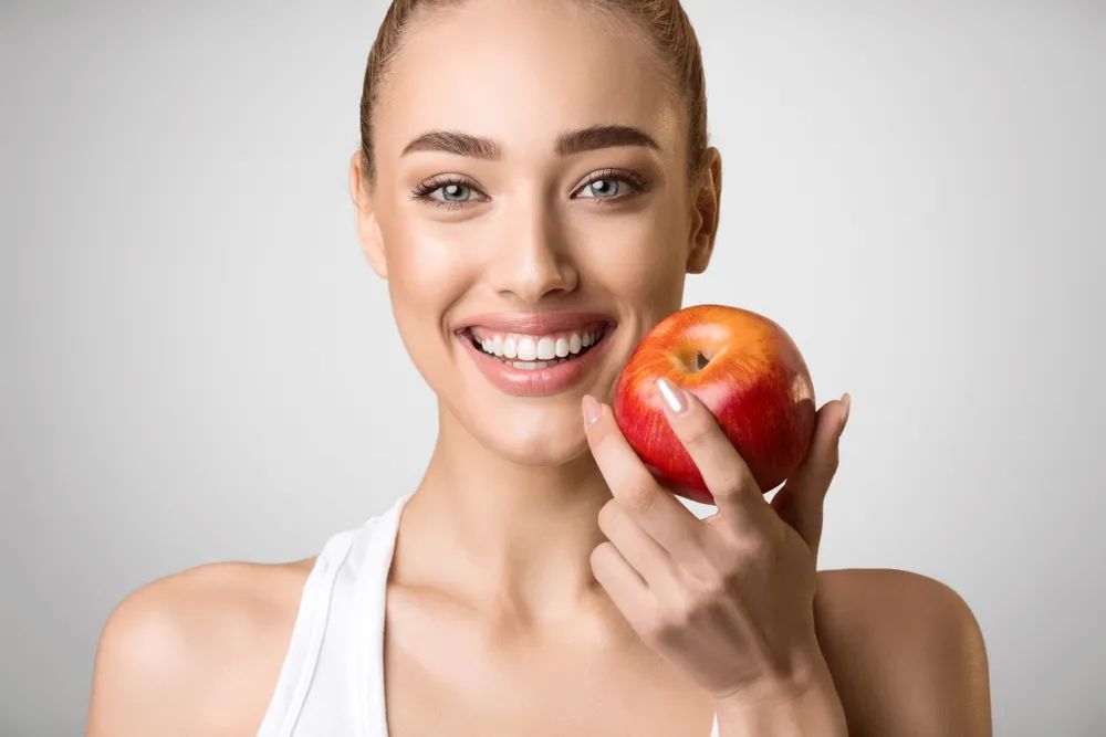 smiling woman with apple in her hands