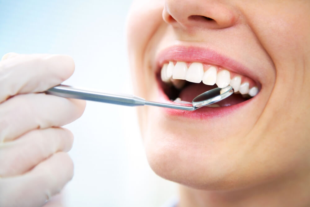 woman checking teeth at dentist