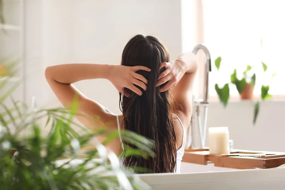 woman in bathtub with healthy wet hair