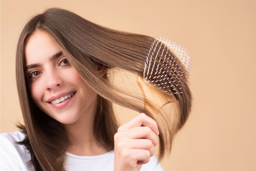 woman brushes her hair