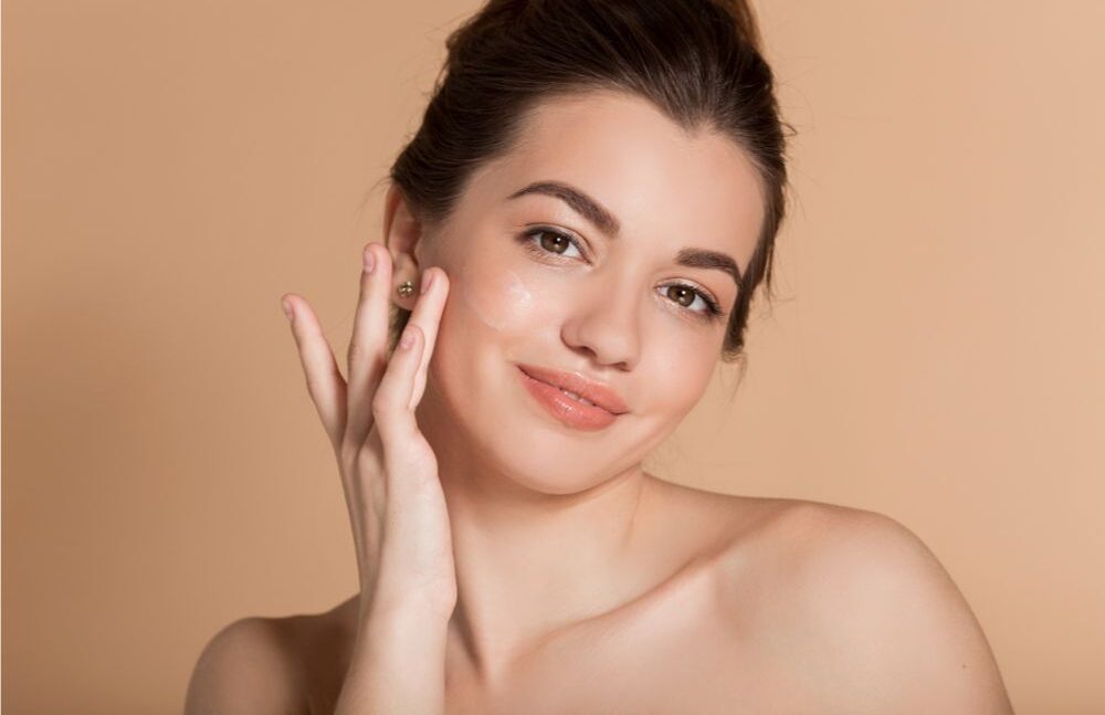 Woman applying serum on her face