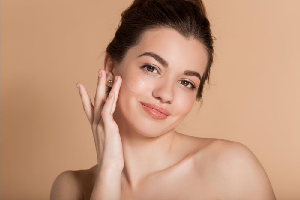 Woman applying serum on her face