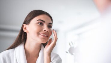 Woman applying serum on her face