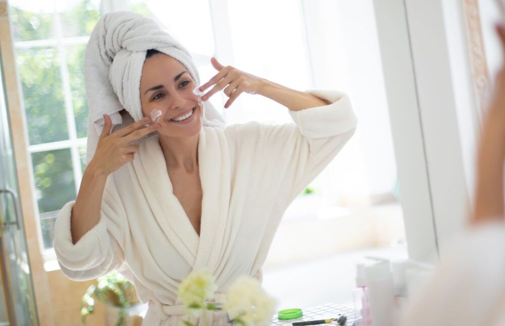 WOMAN APPLYING FACE CREAM