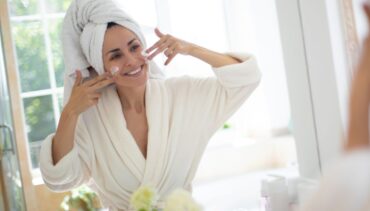 WOMAN APPLYING FACE CREAM