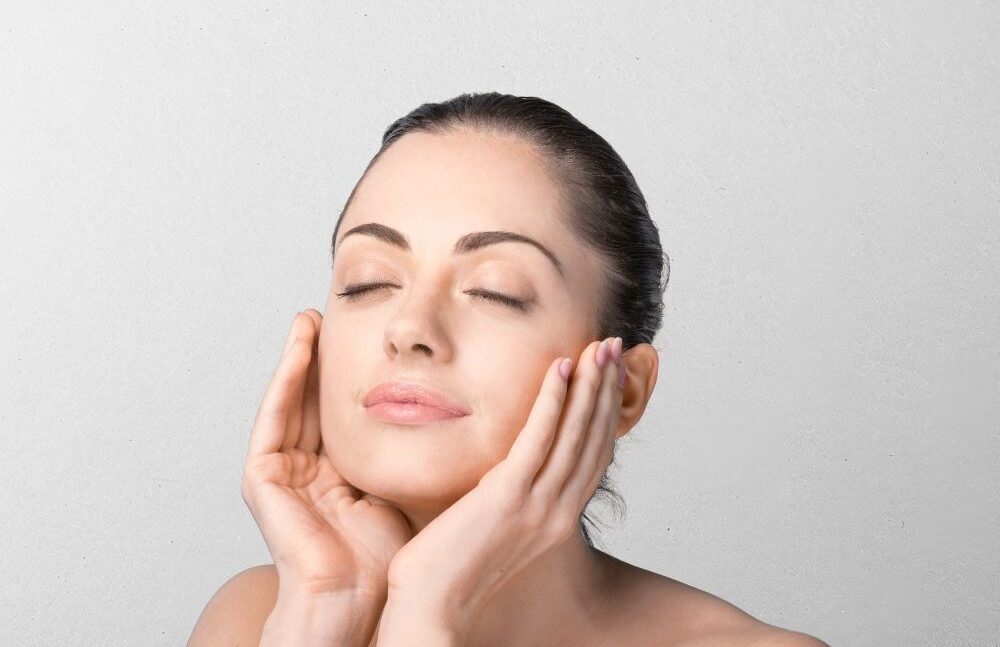 woman applying cream on her face