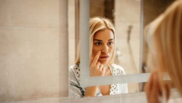 Attractive young woman standing in front of the mirror