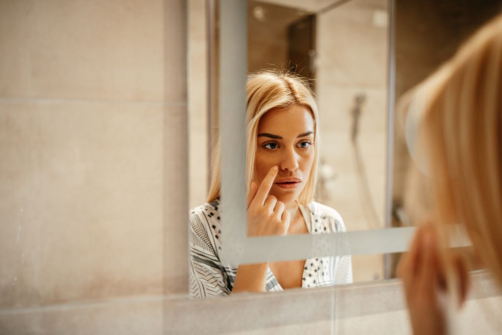 Attractive young woman standing in front of the mirror